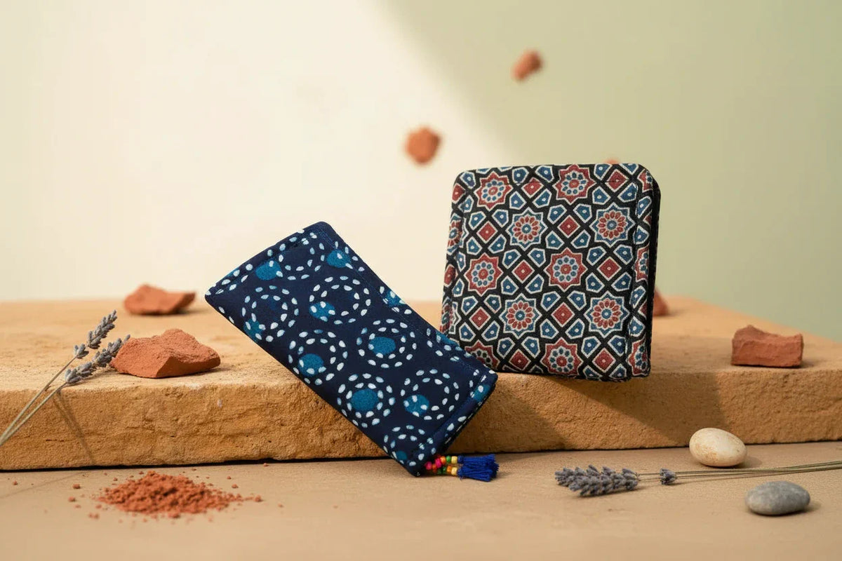 Indigo dot mandala long wallet and black Ajrakh silk wallet with geometric star patterns on sandstone with terracotta and lavender — Velunora handmade Indian gift ideas"